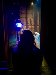 a person standing in front of a stage with lights