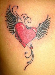 an image of a heart with wings on the back of a woman's shoulder