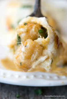 a close up of food on a fork with broccoli and cheese in it