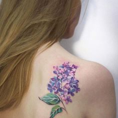 the back of a woman's shoulder with purple flowers on it