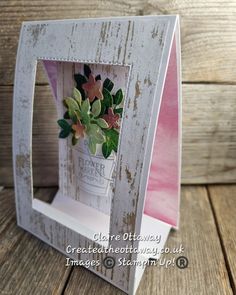 a white wooden frame holding a potted plant