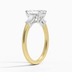 a yellow and white gold engagement ring with a princess cut diamond in the center, on a white background