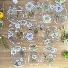 several mason jars filled with flowers on top of a wooden table