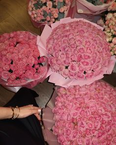 pink roses are arranged on display at a flower shop