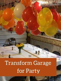 balloons are hanging from the ceiling above a table with chairs and tables set for a party