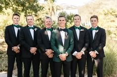 a group of men standing next to each other in tuxedos and bow ties