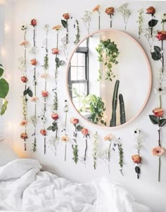 a bedroom with flowers on the wall and a round mirror