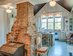 an old brick fireplace in a kitchen next to a stove top oven and countertop