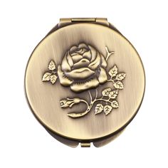 a gold compact case with a rose on it