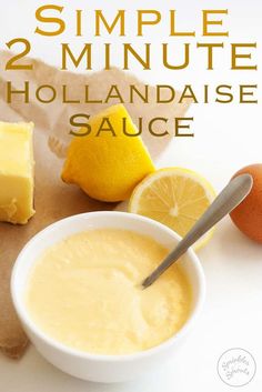 a bowl of hollandaise sauce next to sliced lemons