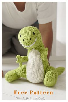 a knitted green dragon sitting on the floor with its legs crossed and eyes closed