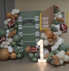 balloon arch with footballs, balloons and numbers for first year down on the field