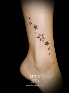 a small ankle tattoo with stars on the top and bottom of its foot, in black ink