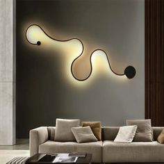 a living room with a couch, table and lamp on the wall above it is an abstract design