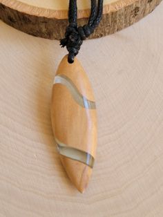 a wooden object is hanging on a black cord