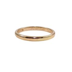 a yellow gold wedding ring with the word love engraved on it's side, in front of a white background