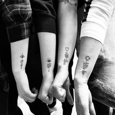 three people holding hands with tattoos on their arms and the words love are written in different languages