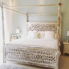 a white bed sitting in a bedroom on top of a floor next to a window