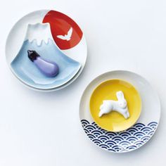 two plates with animals on them sitting next to each other in front of a white background