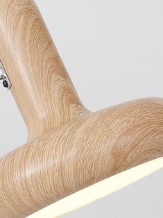 a close up of a wooden chair with a white light on the back and an object hanging from it's arm