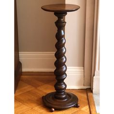 a tall wooden table sitting on top of a hard wood floor next to a wall