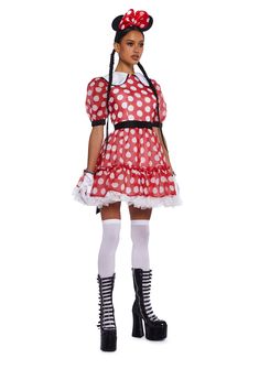 a woman dressed in minnie mouse costume with polka dots on the skirt and headband