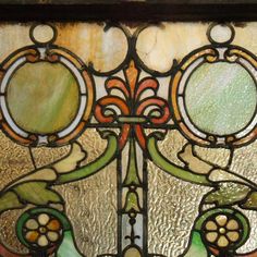 an old stained glass window with flowers and leaves