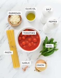 ingredients to make tomato sauce on a white marble countertop with the words tomatoes, pasta, parmesan, parmesan cheese and olive oil