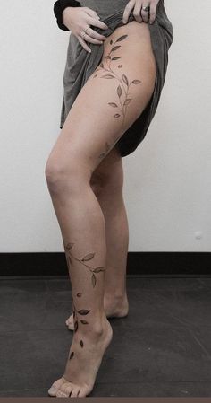 a woman with tattoos on her legs is posing