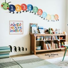 a child's room with bookshelves and toys on the wall in front of it