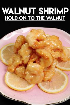 a pink plate topped with lemon slices and shrimp