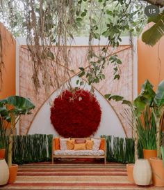 an outdoor area with plants, potted plants and a couch in front of a wall