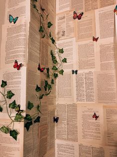 an open book with ivy growing out of it and butterflies flying over the pages on top