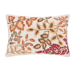 an embroidered pillow with leaves and berries on the front in orange, red, yellow and white