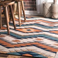 an area rug is shown in front of a brick wall and wooden stools on the floor