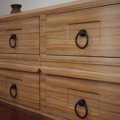 a wooden dresser with black handles and knobs