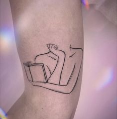 a tattoo on the leg of a person with a book in their lap and an image of a man reading