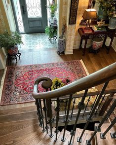 the stairs lead up to an entryway with a rug on the floor and potted plants