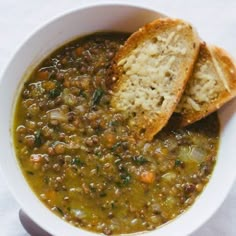 two pieces of bread sticking out of a bowl of soup