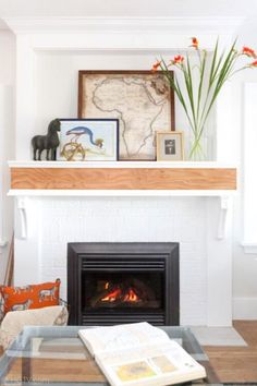 a living room with a fire place and pictures on the fireplace mantel above it