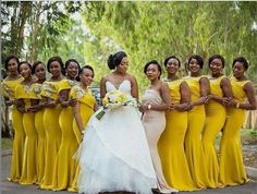 a group of women standing next to each other wearing yellow dresses and holding bouquets