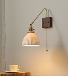 a wall light that is on the side of a wall next to a coffee cup