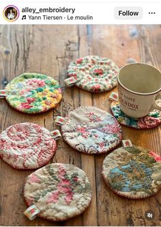 several small coasters on a wooden table with a coffee cup in the middle one