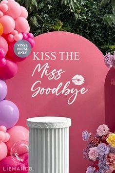 a sign that says kiss the miss goodbye next to some balloons and other things in front of it