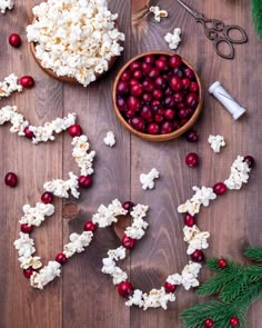 the word love spelled out with popcorn, cranberries and other holiday decorations on a wooden table