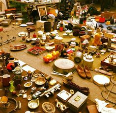 a table filled with lots of clutter and other items on top of the floor