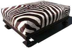 a zebra print ottoman sitting on top of a cement floor