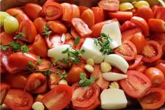 a bowl filled with lots of different types of tomatoes and other vegetables on top of it