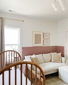 a living room with a white couch and wooden railing in front of a large window