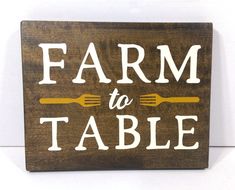 a wooden sign that says farm to table with forks and spoons on the side